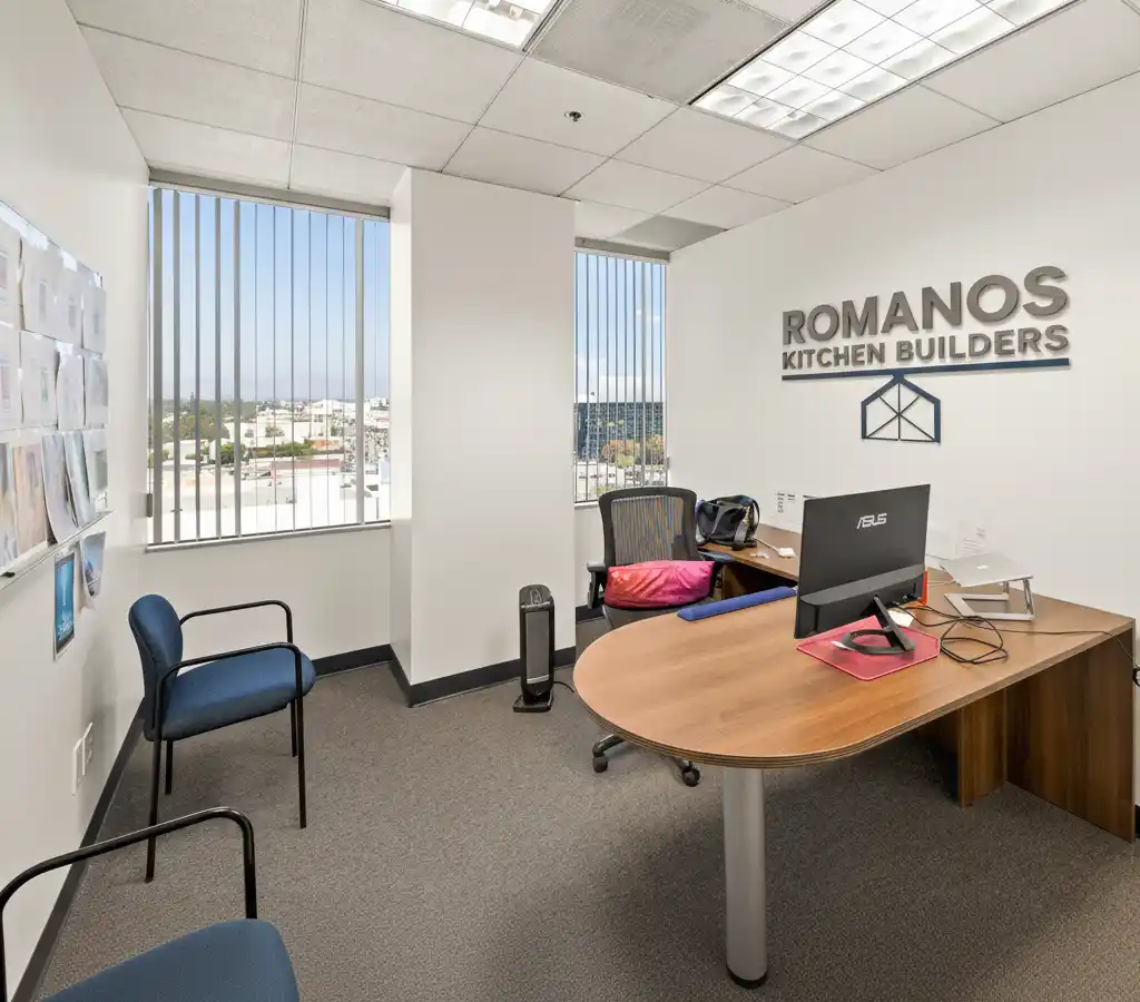 Romanos Kitchen Builders office interior with company logo and branding on wall